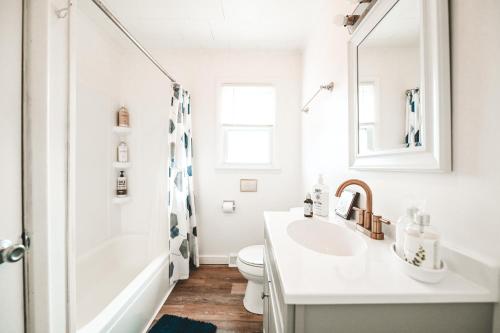 a white bathroom with a sink and a shower at Bay Breeze Retreat in Morehead City