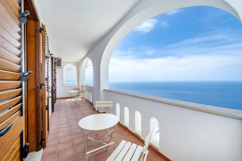 a balcony with chairs and a view of the ocean at Villa Rosy in Amalfi