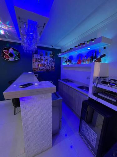 a bar with purple lights in a room at Lindo Apartamento suite country club villas in Santa Rosa
