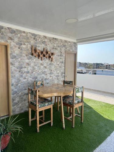 a wooden table and chairs in a room with a stone wall at Lindo Apartamento suite country club villas in Santa Rosa