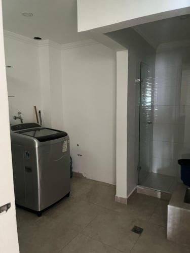 a bathroom with a shower and a trash can at Lindo Apartamento suite country club villas in Santa Rosa