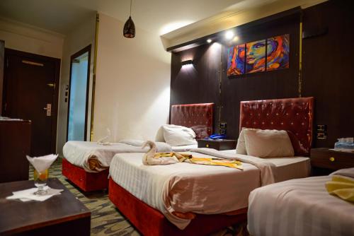 a hotel room with two beds and a room with two tables at فندق الحسين السياحي in Asyut