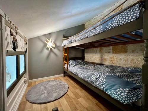 une chambre avec deux lits superposés et un tapis dans l'établissement Mini gîte cabane, à Sainte-Gemme-la-Plaine