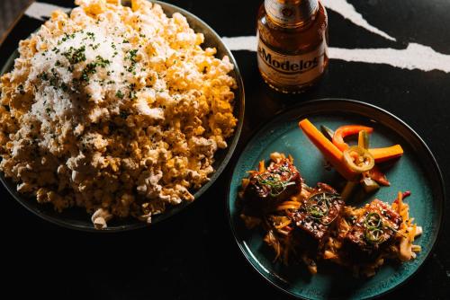 a table with two plates of food and a bottle of beer at Radisson Plaza Hotel at Kalamazoo Center in Kalamazoo