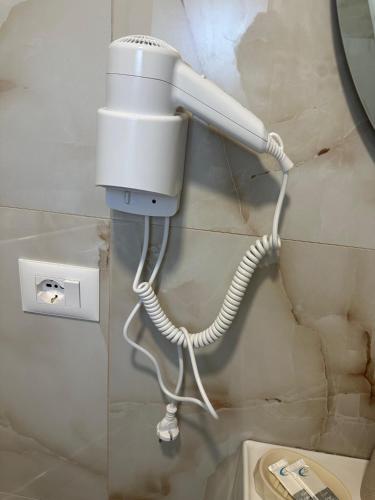 a white phone hanging on a wall next to a toilet at Bujtinat te Mullari 