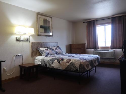 ein Hotelzimmer mit einem Bett und einem Fenster in der Unterkunft Cyclone Lodge in Harlan
