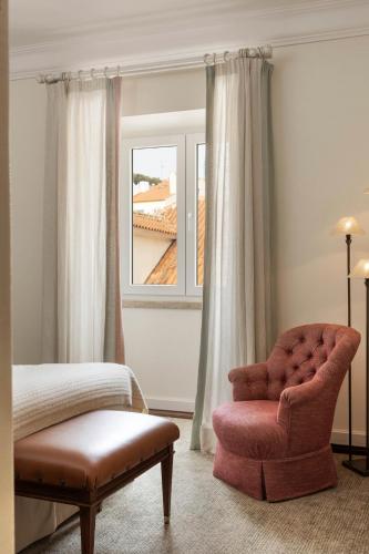 a bedroom with a chair and a window at As Janelas Verdes Inn - Lisbon Heritage Collection - Riverside in Lisbon