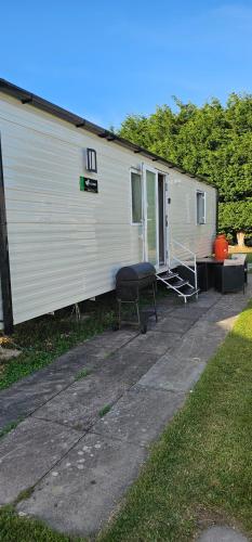 a white trailer with a table and a grill at Serenity Nook in Southview Holiday Park in Burgh le Marsh