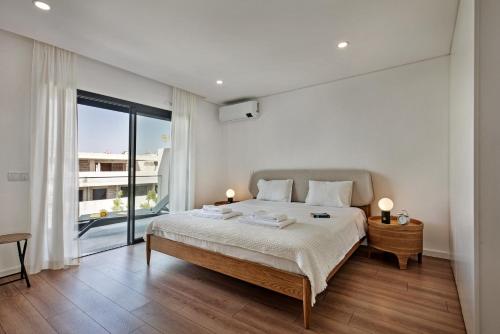 a bedroom with a bed and a large window at Sunny Apartments in Cabanas de Tavira