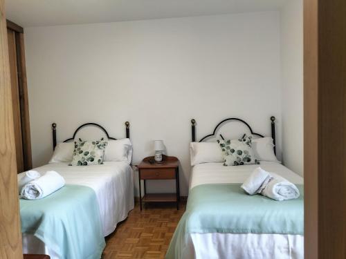 two twin beds in a room with a table at alma de quireza in Santo Tomé
