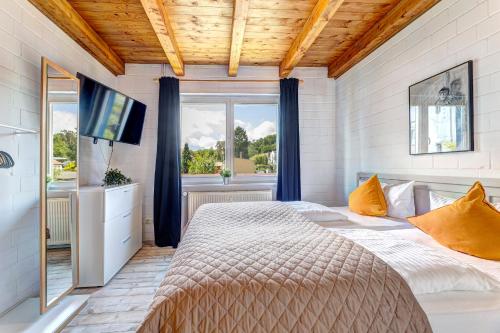 a bedroom with a large bed and a television at Ferienhaus Odin in Bansin