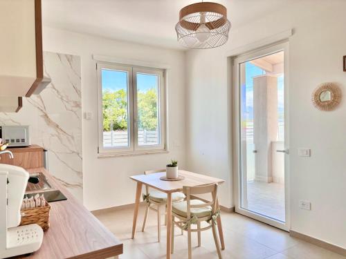 una cucina e una sala da pranzo con tavolo e sedie di Harmonia a SantʼAntonio Abate