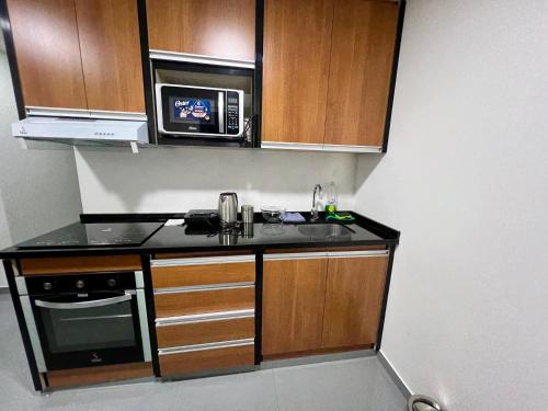 a small kitchen with a sink and a microwave at Departamento con la mejor vista de Equipetrol SCZ in Hamacas