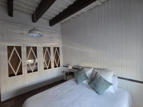 a bedroom with a white bed with blue pillows at AmazINN Places Casa Calabuig Ático Marina Real - No Ascensor- in Valencia
