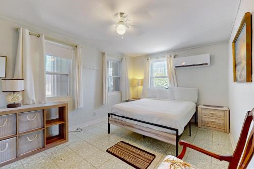 a bedroom with a bed and a dresser and windows at The Kent House in South Padre Island