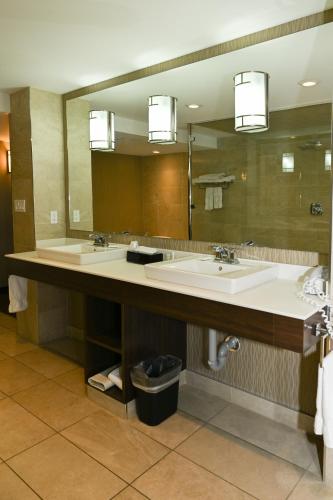 un bagno con due lavandini e un grande specchio di Quality Hotel & Conference Centre a Peace River