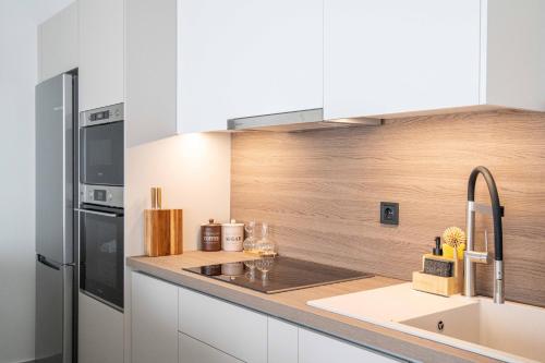 a kitchen with a sink and a refrigerator at Nireas Blue Balcony by Raise in Áno Váthia