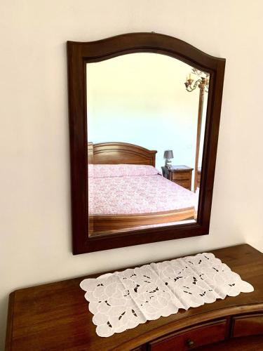 a mirror on a wall above a wooden table at Cascina Nuova in Mombasiglio