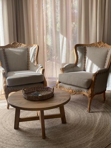 two chairs and a coffee table in a living room at SEASENSE Boutique Beach Villa in Wilderness