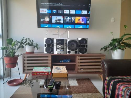 a living room with a tv on the wall at Hermoso apartamento de tres dormitorios con jacuzzi in Chiclayo