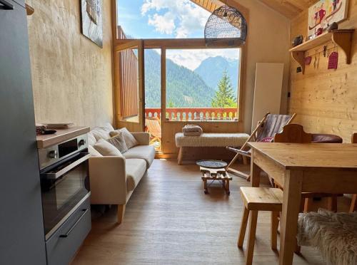 un salon avec une table et une grande fenêtre dans l'établissement L’Éterlou Au pied des pistes, vue montagne, à Champagny-en-Vanoise
