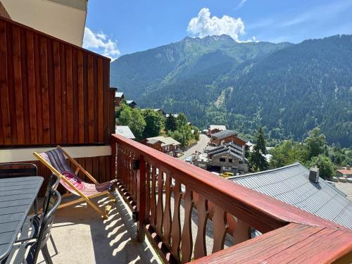 d'un balcon avec une table, une chaise et des montagnes. dans l'établissement L’Éterlou Au pied des pistes, vue montagne, à Champagny-en-Vanoise