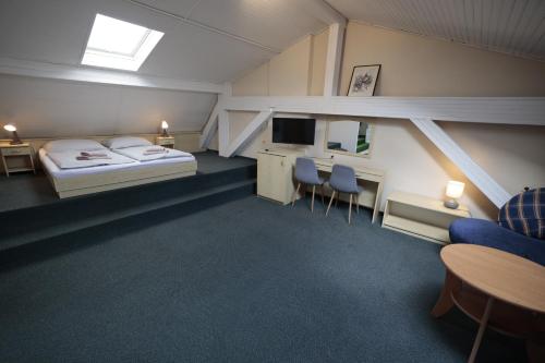 a hotel room with a bed and a desk and chairs at Hotel Zlaté Košice - Self reception in Košice