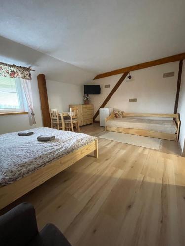 a bedroom with a bed and a wooden floor at Penzion a Vinárna Velký dvůr in Pasohlávky