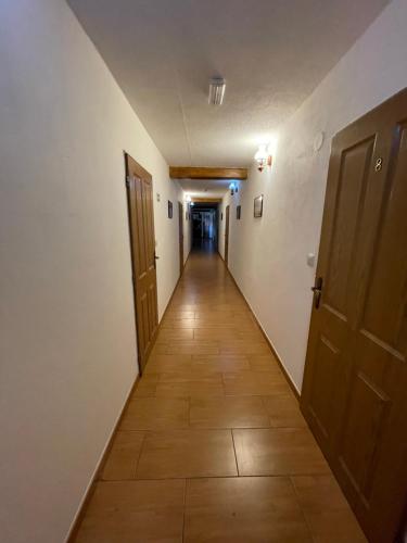 an empty hallway with two doors and a tile floor at Penzion a Vinárna Velký dvůr in Pasohlávky