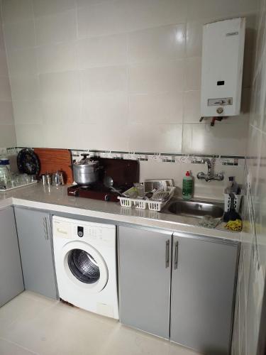 a kitchen with a washing machine and a sink at Apartamento renovado céntrico zona Hamama solo familias in Tetouan