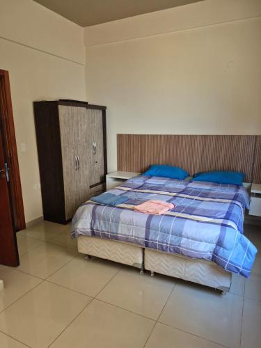 a bedroom with a bed with blue sheets and blue pillows at Departamento lugar estratégico en cde in Ciudad del Este
