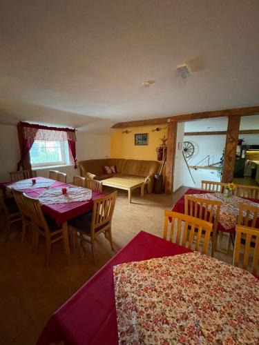 a living room with tables and chairs and a couch at Penzion a Vinárna Velký dvůr in Pasohlávky