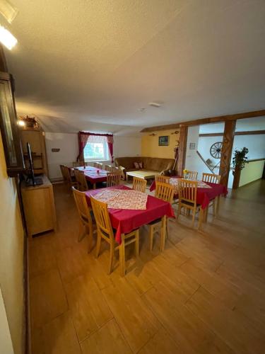 a dining room with a red table and chairs at Penzion a Vinárna Velký dvůr in Pasohlávky