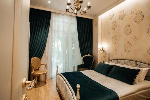 Un dormitorio con una cama y una lámpara de araña. en Moncastro Бутік-готель, en Odessa