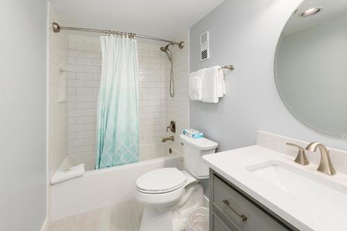a white bathroom with a toilet and a sink at Beach Club #329 in Saint Simons Island