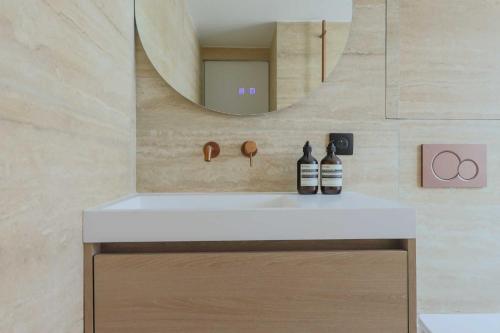 une salle de bain avec un lavabo blanc et un miroir dans l'établissement Magnificent apartment -1BR-4P- Canal Saint-Martin, à Paris