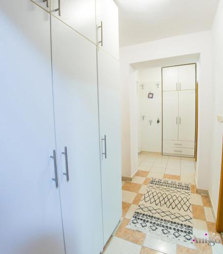 a bathroom with white cabinets and a tile floor at Apartment La Vie in Mostar