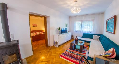 a living room with a blue couch and a television at Apartment La Vie in Mostar