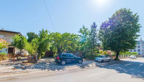 two cars parked in a parking lot next to trees at Apartment La Vie in Mostar