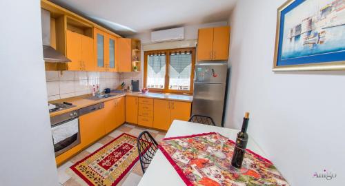 a kitchen with orange cabinets and a table with a table sidx sidx at Apartment La Vie in Mostar