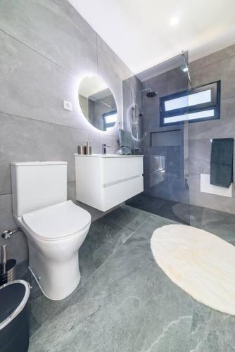 a bathroom with a white toilet and a sink at Ocean Valley by Mth in Ribeira Brava