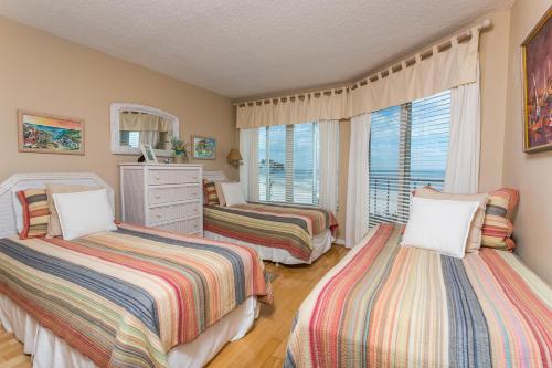 a bedroom with two beds and a window at Beach Club #410 in Saint Simons Island