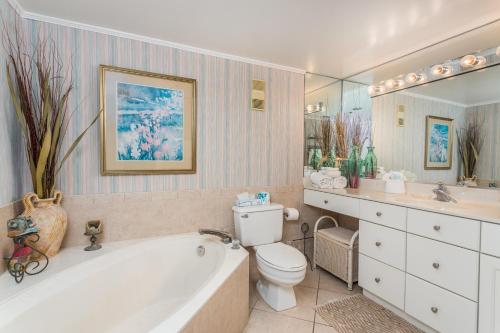 a bathroom with a tub and a toilet and a sink at Beach Club #410 in Saint Simons Island