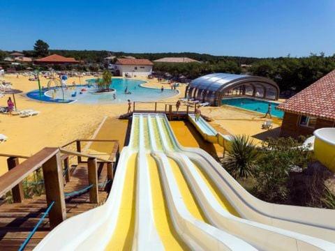 un parc aquatique avec un toboggan et une aire de jeux dans l'établissement KOKUA VACANCES Mobil Homes Résidentiels camping 4 étoiles MIMIZAN PLAGE, à Mimizan-Plage