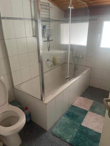 a bathroom with a tub and a toilet at Dearm Vacation home easy to arrive in Spiez