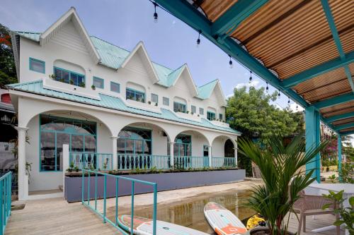 ein großes weißes Gebäude mit Surfbrettern davor in der Unterkunft Adra Hostal Peten in Flores