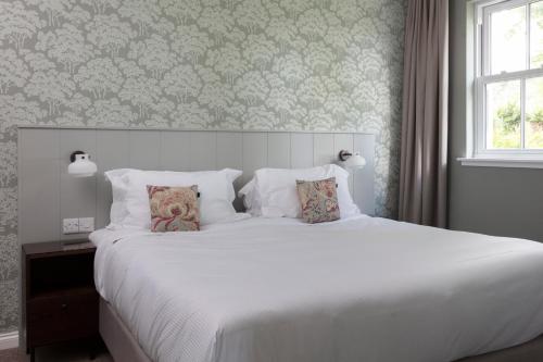 a bedroom with a large white bed and a window at SCHLOSS Roxburghe, part of Destination by Hyatt in Kelso