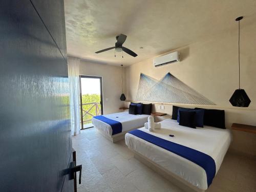 ein Hotelzimmer mit zwei Betten und einem Fenster in der Unterkunft sunsteps casa holbox in Holbox