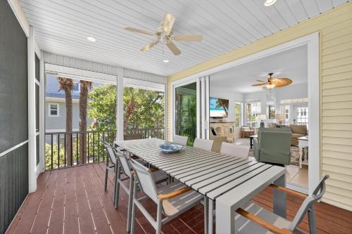 a screened porch with a wooden table and chairs at Sea Oats Oasis in Sanibel