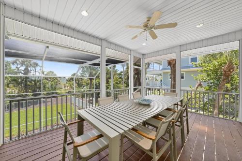 a screened porch with a wooden table and chairs at Sea Oats Oasis in Sanibel